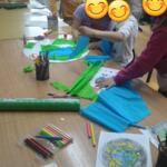 Dzieci podczas warsztatów ekologicznych przy stolikach.