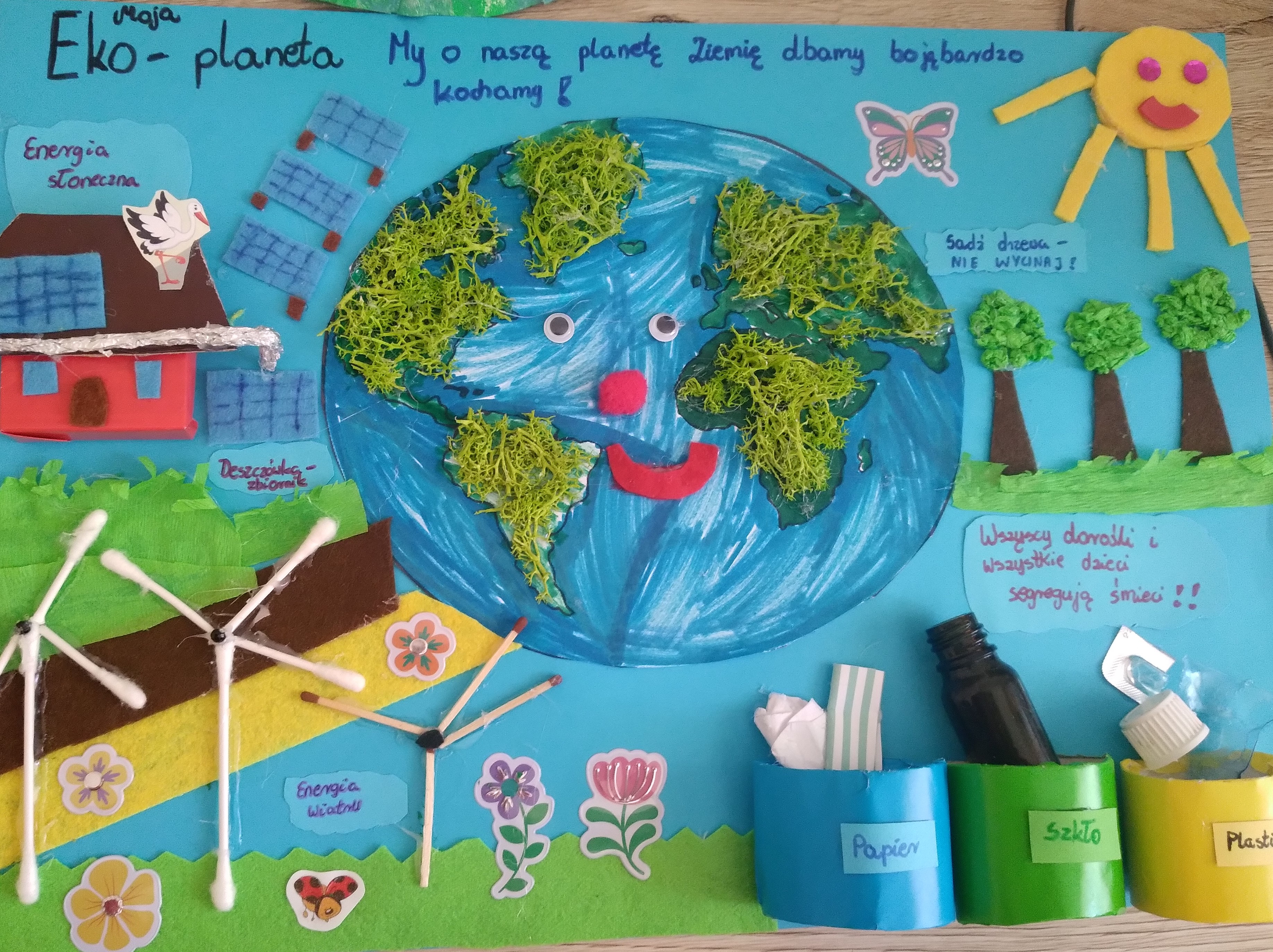 Competition entry - a smiling planet with renewable energy sources.