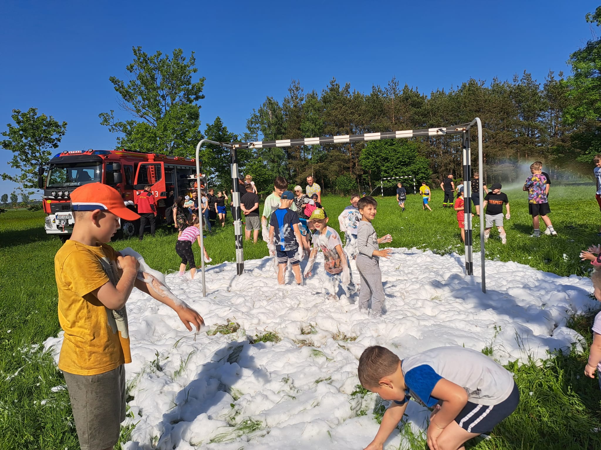 A group of children playing a foam extinguisher soccer match.