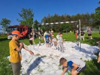 A group of children playing a foam extinguisher soccer match.