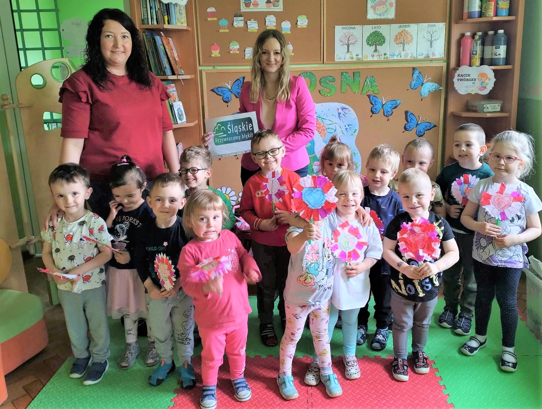 Preschoolers accompanied by the Eco-Manager with their self-made eco-flowers.