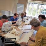 Women from the Senior Club sewing eco-friendly bags. 