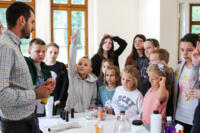 An eco-manager with a group of children conducting physical experiments.