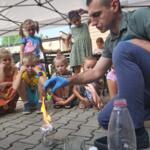 An eco-manager with a group of children conducting physical experiments.