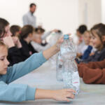 An eco-manager with a group of children conducting physical experiments.