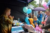 Eco-manager at a booth during the picnic. In front of the tent, a group of participants.