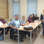 A group of eco-managers sitting in benches and listening to the subregional eco-manager's presentation.