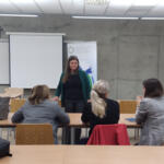 A group of eco-managers sitting in benches and listening to the subregional eco-manager's presentation.