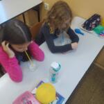 A group of girls painting pictures on the table.
