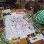 A group of girls painting pictures on the table.
