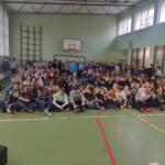 Children sitting on the floor at school and watching a performance.