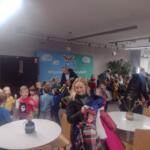 Children sitting on the floor at school and watching a performance.
