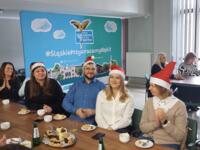 A group of eco-managers in Santa hats sitting at a table.