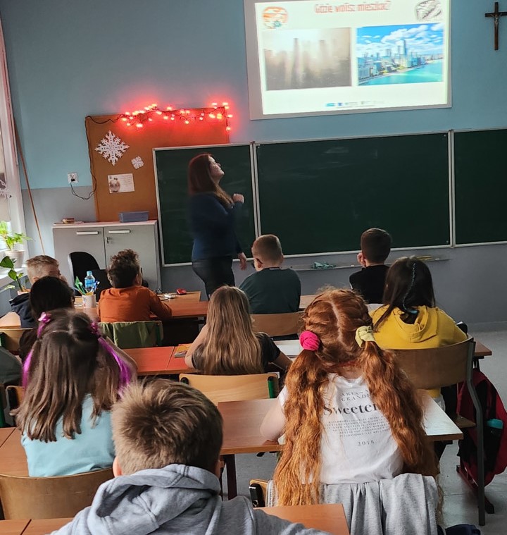 A group of students sitting in desks and listening to the presentation of the eco-manager.