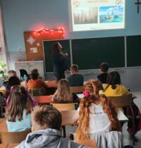 A group of students sitting in desks and listening to the presentation of the eco-manager.