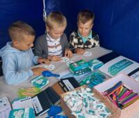 Children watching educational materials at the eco-advisor's booth.